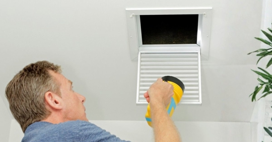 homeowner checking an indoor AC vent with a concerned expression