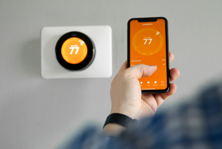 Man using app to turn up thermostat.