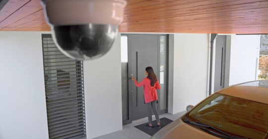 Woman entering house using fingerprint scanner