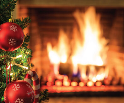 Fire safety Tip for the holiday season. Image of a Fireplace with fire burning and a Christmas tree with ornaments.