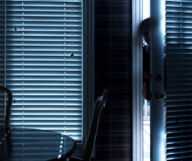 a man peeking through a door at night