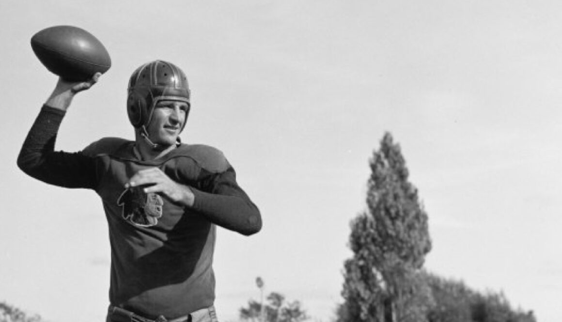 a black and white photo of sammy baugh throwing a football