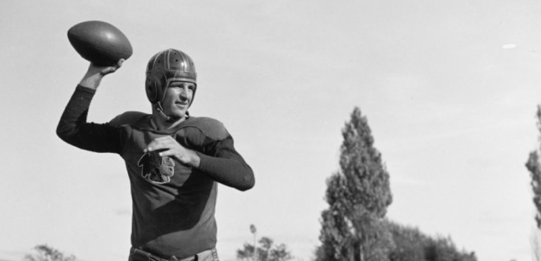 a black and white photo of sammy baugh throwing a football